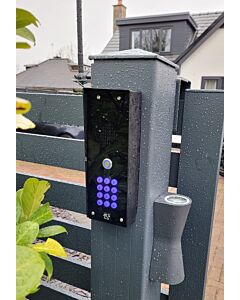 The AES Cellcom Lite GSM Intercom with Keypad installed on a grey aluminium gate in rainy weather
